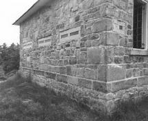 Vue en angle de la résidence fortifiée du maître-éclusier de Jones Falls, qui montre les murs extérieurs en blocs de pierre rustiquée, 1989.; Parks Canada Agency / Agence Parcs Canada, 1989.