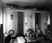 Interior view of the Fog Alarm building, showing the surviving machinery, 1990.; Parks Canada Agency / Agence Parcs Canada, 1990.