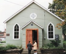 View of the main façade of the R. Nathaniel Dett British Methodist Episcopal Church, showing the wood-frame construction and modest porch entry.; Parks Canada Agency / Agence Parcs Canada.