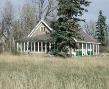 Southwest view showing the 1927 addition to the original ranch house (now demolished). The open verandah along the south wall (former location of original ranch house wall) was constructed at the time of demolition.; Glenbow Museum NA-460-22