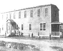 Exterior view of front and right facades, International Pulp and Paper Company Staff House, Deer Lake, NL, in 1953 during use as a school.; HFNL 2005