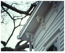 Showing detail of eave bracketting, clapboard siding, and window hood moulding; Lighthouse Museum Collection
