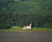 Taken from the opposite side of the Petitcodiac River, this photo shows the Sainte-Anne Chapel, the presbytery and a portion of the cemetery.; La Société historique de la Valleé de Memramcook
