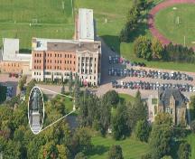Aerial view showing the placement of the Lefebvre statue in front of the former Collège Saint-Joseph building, with the Monument Lefebvre on the extreme right.; La Société historique de la Valleé de Memramcook et le Village de Memramcook