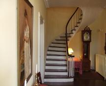 This photograph shows the spiral staircase and the portrait of Mrs. Ross in the foreground to the left, 2007.; Town of St. Andrews