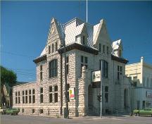 Vue en angle de l'édifice public de Portage la Prairie, montrant deux façades principales qui mettent en valeur l'insertion de l'édifice à une intersection, 1982.; Parks Canada Agency/Agence Parcs Canada, 1982.