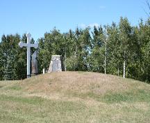 Contextual view, from the southeast, of the Ukrainian Pioneer Mass Grave Site, Oakburn area, 2006. The grave mound is identifiable as the mound in the foreground.; Historic Resources Branch, Manitoba Culture, Heritage and Tourism, 2006