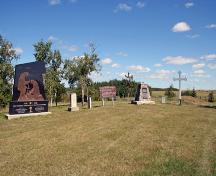 Contextual view, from the southwest, of the Ukrainian Pioneer Mass Grave Site, Oakburn area, 2006, showing the range of commemorative markers at the site.; Historic Resources Branch, Manitoba Culture, Heritage and Tourism, 2006
