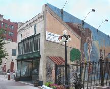Contextual view, from the northeast, of the Macdonald Shoe Store (also showing the 1982-83 mural that has helped make the building a local landmark), Winnipeg, 2007; Historic Resources Branch, Manitoba Culture, Heritage, Tourism and Sport, 2007