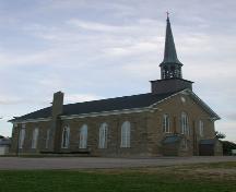 Vue en angle du côté de l'église qui montre la fenestration gothique originale.; PNB 2004