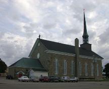 Vue arrière de l'église qui montre un abri en pierre à la porte d’entrée latérale.; PNB 2004