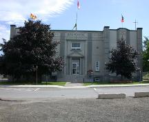 The image of the façade displays symmetrical geometry, embellished with grooved pilasters, and a serrated frieze consistent with the Art Déco Style.; PNB 2004