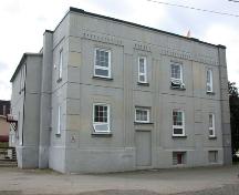 The image displays the corner pilasters, the cubic structure of the building as well as the minimal fenestration framed by simple geometric motifs.; PNB 2004