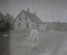 Showing child with house in background; Private Collection, Anna Campbell