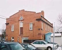 View of the primary north and east brick clad two storey facades of the North Telephone Exchange with a prominent end pediment. The two stories are emphasized by continuous horizontal bands and an upper metal projecting cornice. (2004); City of Edmonton, 2004