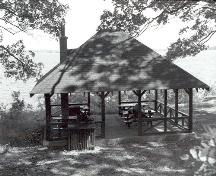 Vue de l'arrière de l'abri de pique-nique, qui montre la structure ajourée et l’espace intérieur sans cloisons, 1992.; Parks Canada Agency / Agence Parcs Canada, 1992.
