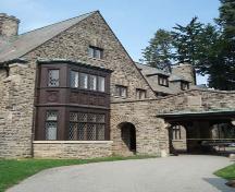 Featured is the façade with recessed entry and projecting stone arcade and covered driveway.; Martina Braunstein, 2007.