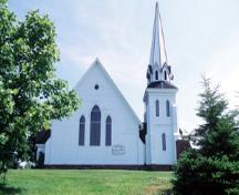 Vue de l'extérieur de l'église unie de Tryon, qui montre ses formes et sa composition simples et hardies, y compris sa tour proéminente presque détachée, et ses surfaces horizontales massives ininterrompues, 1995.; Parks Canada Agency / Agence Parcs Canada, J. Butterill, 1995.