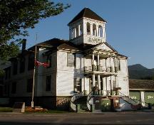 Vue de la façade de l’hôtel de ville de Kaslo, qui montre le portique avant sur deux étages et les escaliers, et le beffroi, 2003.; Parks Canada Agency / Agence Parcs Canada, 2003.