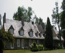 Vue générale de la maison Trestler, qui montre le toit aigu à deux versants avec lucarnes, les larges larmiers et les cheminées multiples, 2001.; Parks Canada Agency / Agence Parcs Canada, 2001.