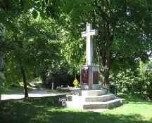 Vue du lieu historique national du Canada du Site-de-la-Falaise, qui montre le monument comprenant une croix placée sur un piédestal, au sommet d’un escalier octogonal, et qui rappelle la croix érigée par Dollier et Bréhant, 2005.; Parks Canada Agency / Agence Parcs Canada, 2005.