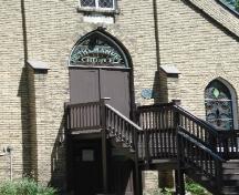 Of note is the gothic window above the door that displays the Church's name.; Kendra Green, 2007.