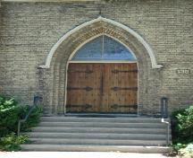 Featured is the double wooden doorway topped by arched gothic transom on the façade.; Kendra Green, 2007