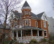 Of note are the wrap-around veranda, three-storey tower with conical roof and oriel window.; Kayla Jonas, 2008.