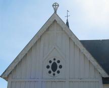 Cette image montre des motifs en croix qui décorent les boiseries du pignon ouest.; PNB 2005