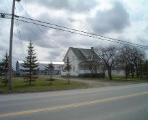 This image presents the house in the middle of the yard with the sheet-metal barn in back.; Village of Saint-Quentin