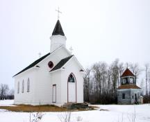Contextual view, from the southeast, showing the church building and bell tower of Sts. Peter and Paul Roman Catholic Church, Elphinstone area, 2006; Historic Resources Branch, Manitoba Culture, Heritage and Tourism, 2005