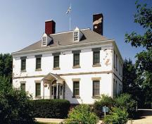 Exterior view of Acacia Grove / Prescott House, showing its rectangular massing, truncated, slightly  
bellcast hipped roof with dormers and massive chimneys at each end.; Parks Canada Agency / Agence Parcs Canada.