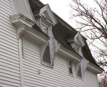 Pedimented dormers with vertical woodwork serving as extended brackets; Bernard LeBlanc