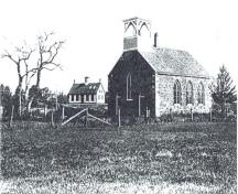 Image historique de l'église anglicane de St. Paul avec la première école Grand Harbour en arrière-plan. L'école se trouve à l'autre côté du ruisseau.; Grand Manan Archives