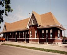 Vue générale de la gare de VIA Rail/Canadien National de Portage la Prairie, montrant la façade sud, 1992.; Agence Parcs Canada / Parks Canada Agency, 1992.