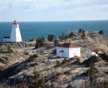 La maison du gardien du phare Swallowtail à l'hiver 2010, montrant les fenêtres condamnées. Le phare Swallowtail se trouve à gauche.; Grand Manan Historical Society