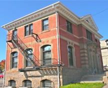 This image, taken from the southeast, shows the original iron fire escape against the red brick. Arched cut-stone window headers highlight the exterior.; Village of Hillsborough
