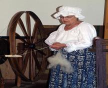 Image montrant Betty Adams travaillant avec un rouet; Village of Dorchester