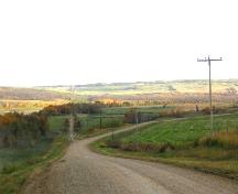 View south at site location on low ground, middle of frame, right of road, 2004.; Government of Saskatchewan, Marvin Thomas, 2004.