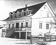 Vue générale de la maison Girard, montrant la volumétrie groupée sur deux étages et demi avec un toit de pente moyenne à larmier, 1987; Environment Canada, Quebec / Environnement Canada, Québec, 1987.