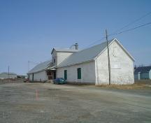 This image presents the warehouse with its cedar shingle cladding and its many loading doors.; Village of Saint-Quentin