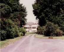 Vue de l'entrée principale de la maison Inverarden, qui montre son porche à toit pyramidal abritant une entrée centrale d’inspiration classique, flanquée de fenêtres à battant, 1994.; Parks Canada Agency / Agence Parcs Canada, 1994.