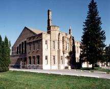 Vue en angle du manège militaire de Cornwall, qui montre la brique chamois et les tours d'angle, 1994.; Department of Public Works / Ministère des Travaux publics, 1994.