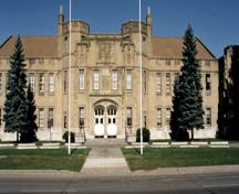 Façade du manège militaire de Cornwall, qui montre l’imposante volumétrie symétrique de la façade principale de deux étages, 1994.; Department of Public Works / Ministère des Travaux publics, 1994.