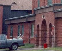Detail view of Building A-78, showing the main central arched opening, flanked by two smaller arched openings.; Parks Canada Agency / Agence Parcs Canada.