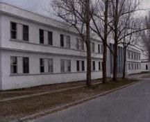 Vue de la façade générale des quartiers pour caporaux et soldats, qui montre l’horizontalité générale.; Department of National Defence / Ministère de la Défense nationale