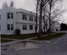 General view of the Junior Ranks Quarters, showing the wrap-around continuity of the projecting belt courses.; Department of National Defence / Ministère de la Défense nationale