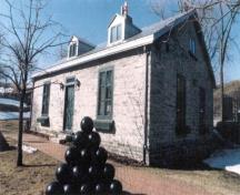 View of the exterior of Building 4, showing the neoclassical details above the doors and windows consisting of the rectangular mullioned transom and the radiating voussoirs.; Parks Canada Agency / Agence Parcs Canada.