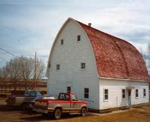 Corner view of Building 15, showing the simple rectangular massing, and the rainbow or gambrel roof, 1989.; Department of Agriculture and Agri-Food / Ministère de l'Agriculture et de l'Agroalimentaire, 1989.