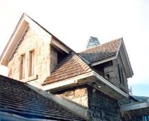Vue détaillée du bâtiment d’entretien, qui montre le toit à comble en croupe avec ses gâbles croisés, 1988.; Parks Canada Agency / Agence Parcs Canada, 1988.